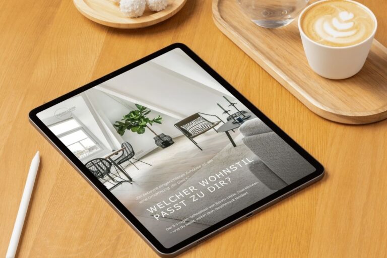 Tablet zeigt das Cover 'Welcher Wohnstil passt zu dir?' von Raum-Liebe, daneben Kaffee und Stift auf Holztisch