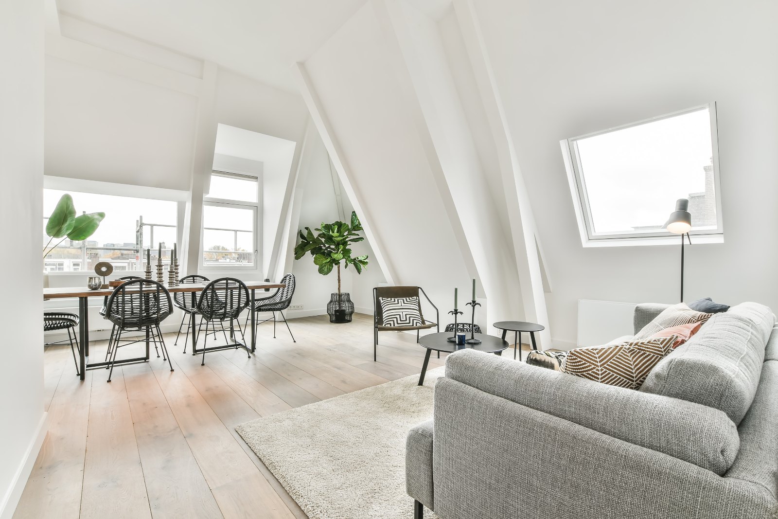 Heller, gemütlicher Wohnraum mit Sofa und Esstisch im Tageslicht